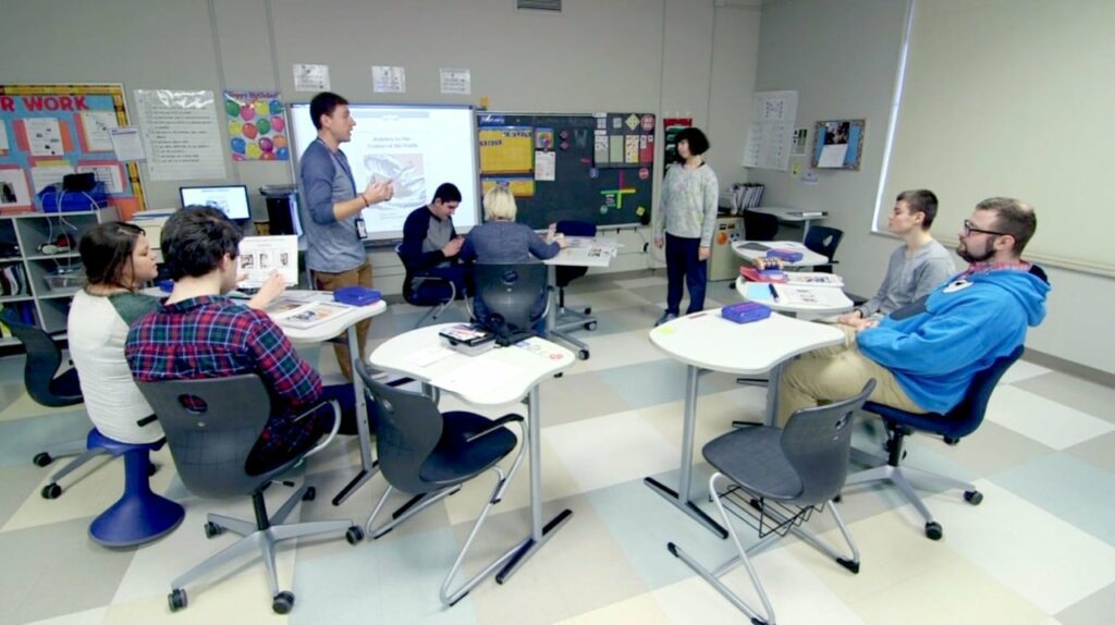 Erlind-Header - Building Wings high school special education teacher works with students in a classroom.
