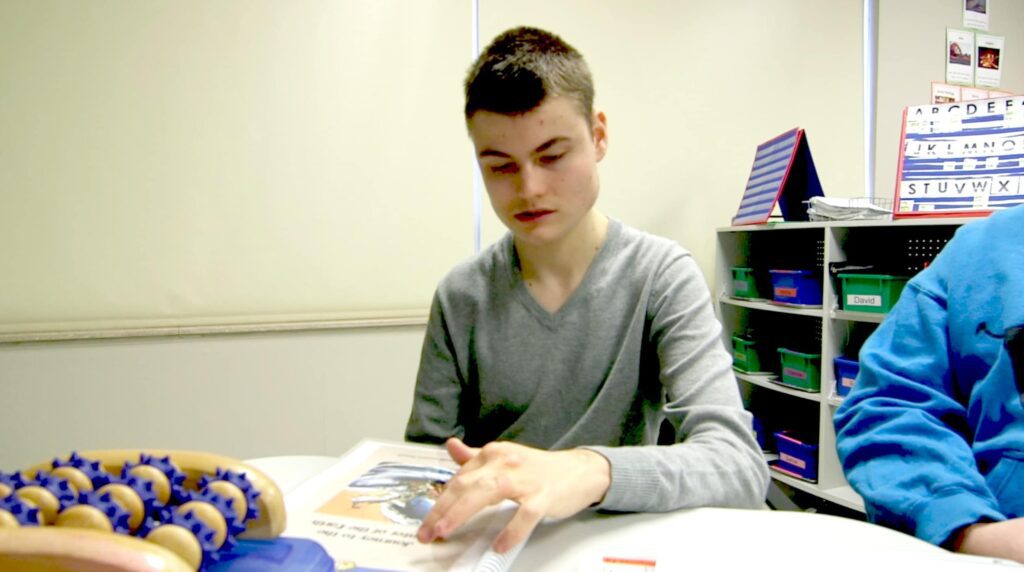 Journey - Building Wings Student reads a book at a desk.