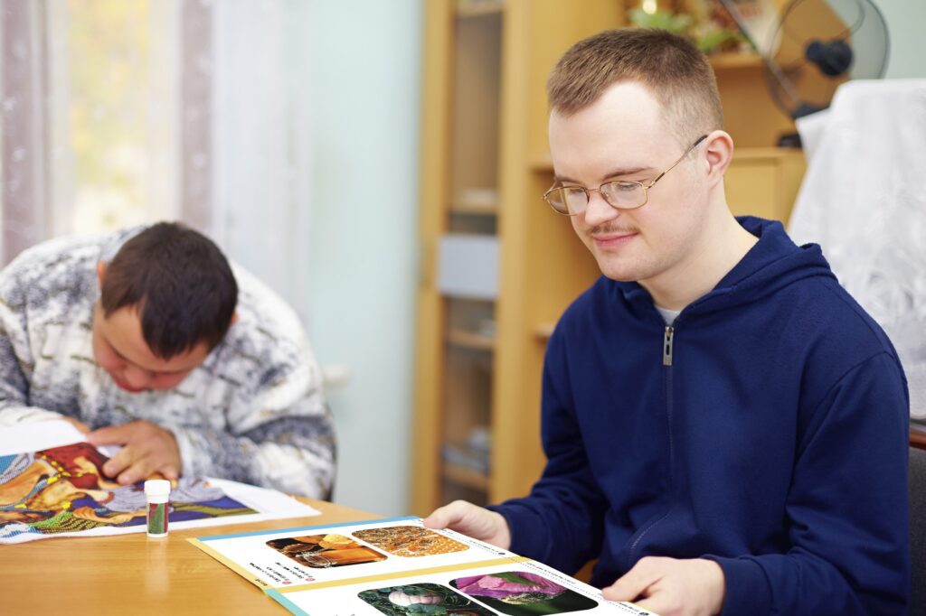 Article-Photo-1 - Building Wings A student in a blue hoodie reads a Readtopia book in their home.