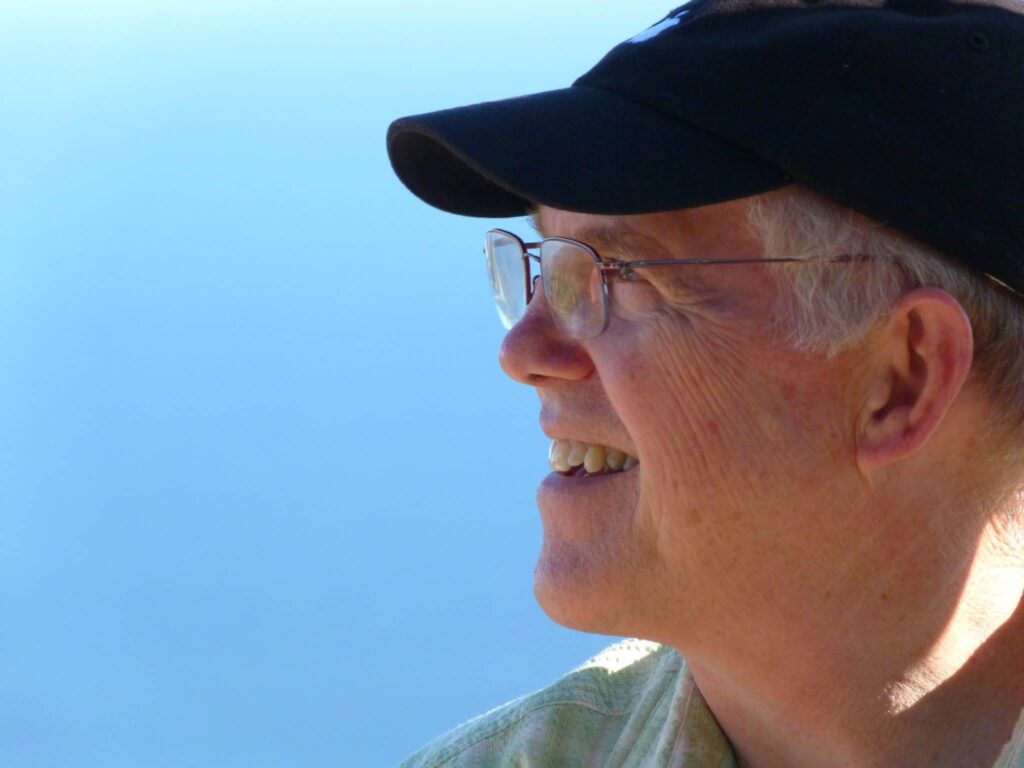 Jerry-2048x1536 - Building Wings Jerry Stemach smiles while looking off to the side in front of a bright blue sky.