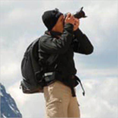 Mike Byrne uses his camera to take a picture of something outdoors.