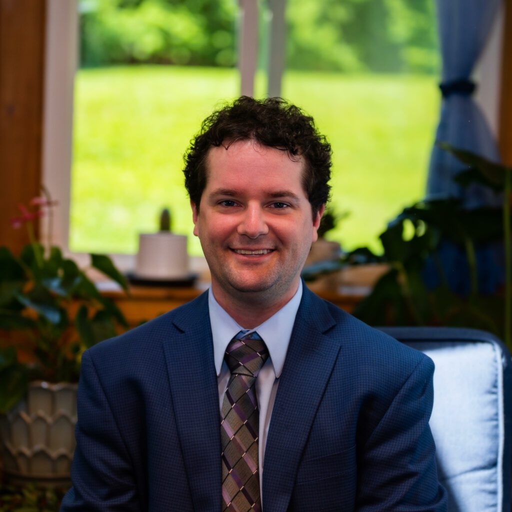 michael mccormick headshot 2022 via JJ - Building Wings Michael McCormick in a navy suit and purple tie.