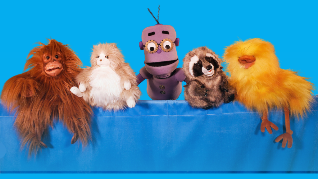 Using Puppets in Early Childhood Education - Building Wings Blue background with five furry puppets including the purple robot Geartrude puppet from ReadtopiaGO