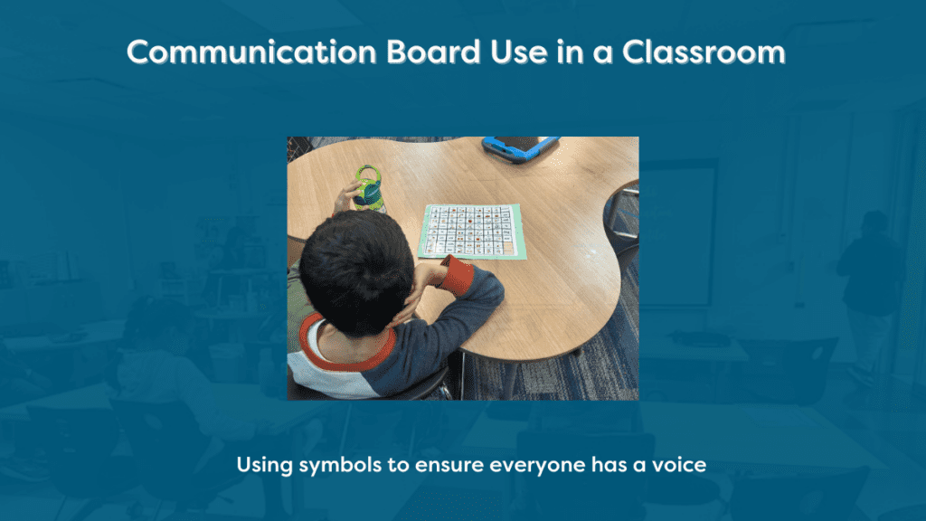 Communication Board Use in a Classroom - Building Wings A boy seated at a classroom table with a communication board in front of him