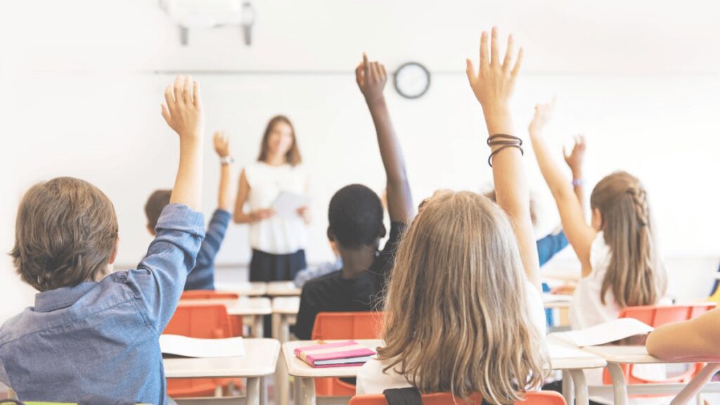 develop critical thinking featured - Building Wings A classroom with students raised to participate in classroom discussion